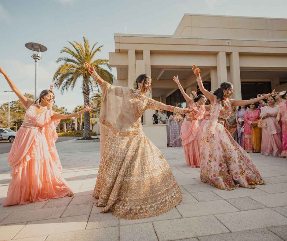 Bride doing choreographed dance with bridesmaids during baraat