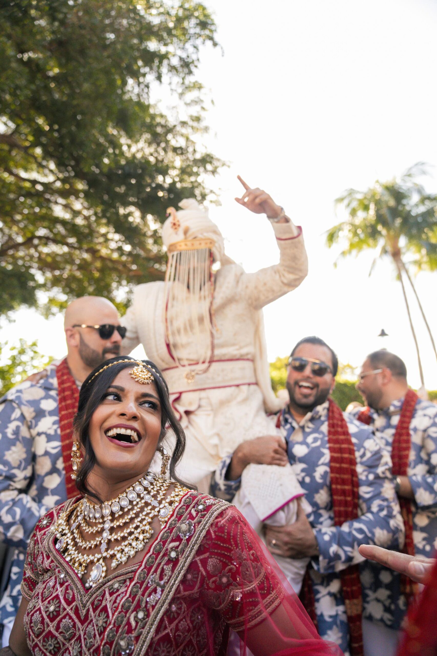 Smiling South Asian Couple celebrating during the baraat on a palm tree lined drive leading up to the Ritz Carlton Key Biscayne
